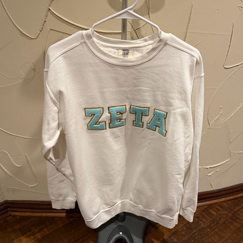 White Zeta Tau Alpha crewneck sweatshirt with blue/gold lettering